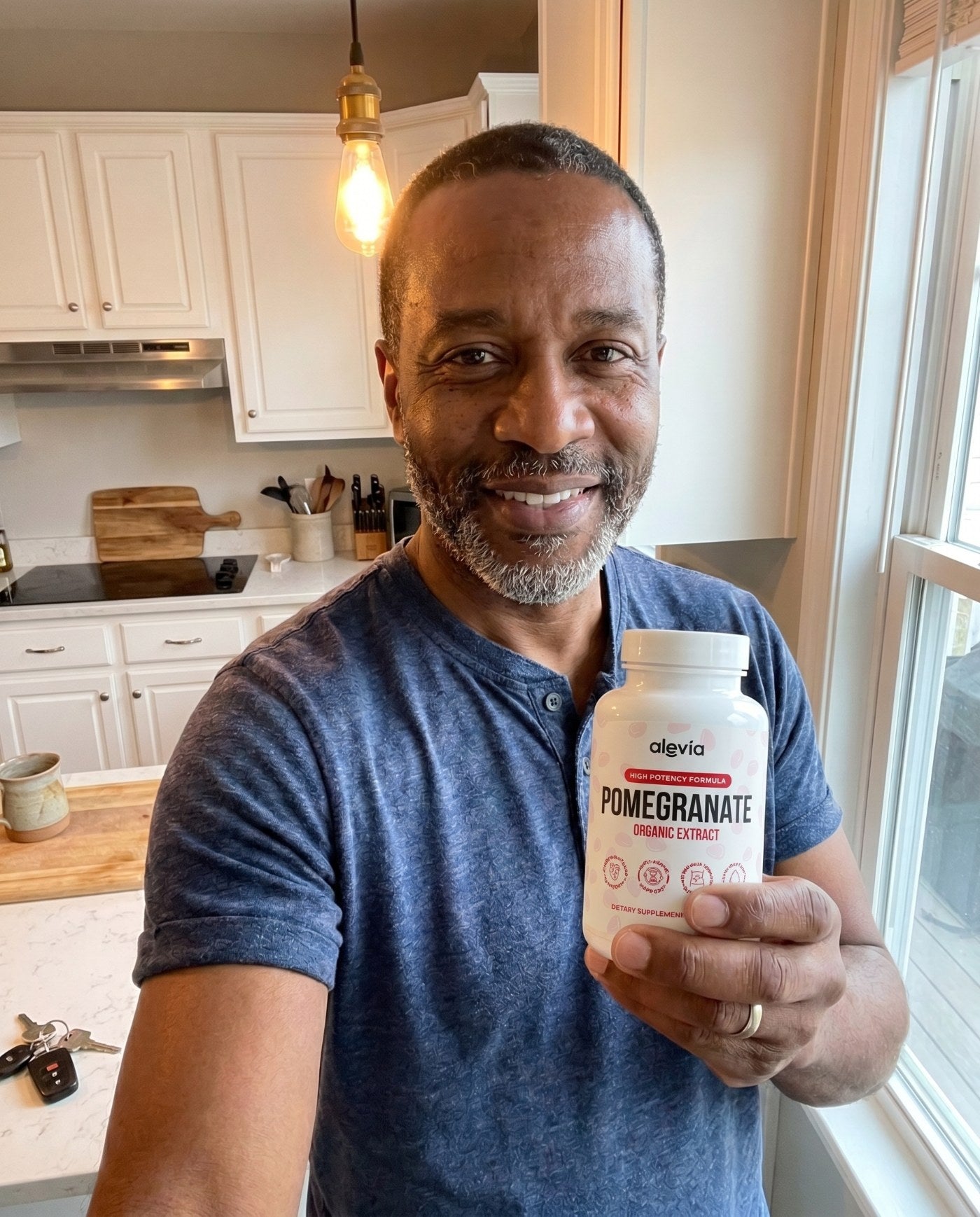 Man holding a bottle of Auniva Pomegranate Organic Extract in his kitchen